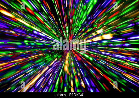 Diagonal blurred lines of color lights is converged on dark background. Colorful lights blurred by motion. Stock Photo