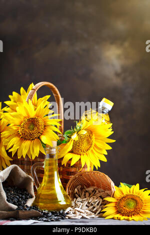 Closeup photo of sunflowers and sunflower oil with seeds on on a wooden table. Bio and organic concept of the product. Stock Photo