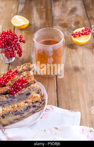 Sweet home-made pie with berries and nuts for breakfast. Homemade baking. Berries of red currants and lemon. Brown wooden background. Free me for text or postcard Stock Photo