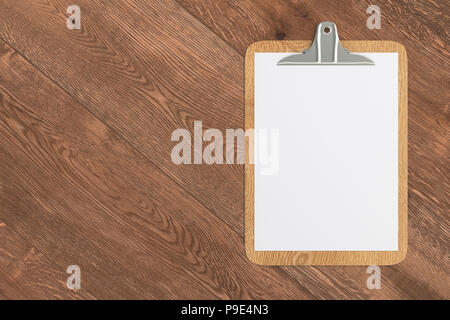 Wooden clipboard with blank white paper pages isolated on black ...