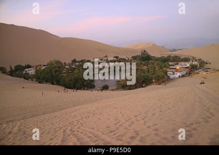 Breathtaking view of Huacachina, the oasis town as seen from the sand dune at sunset, Ica region, Peru Stock Photo