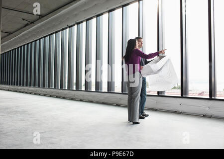 Two architects working on business plans in a new raw business space. Stock Photo
