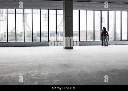 Two architects working on business plans in a new raw business space. Stock Photo
