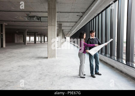 Two architects working on business plans in a new raw business space. Stock Photo