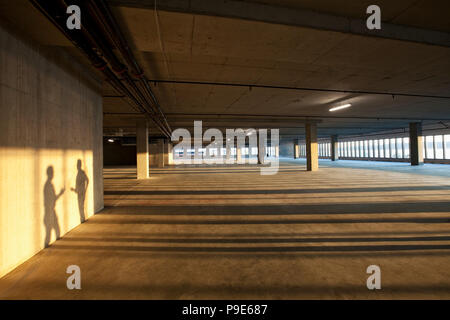 Shadows of two men shaking hands on the wall of an empty raw business space. Stock Photo