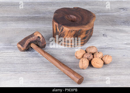 hammer nutcracker and walnuts on anthracite gray wood in background Stock Photo