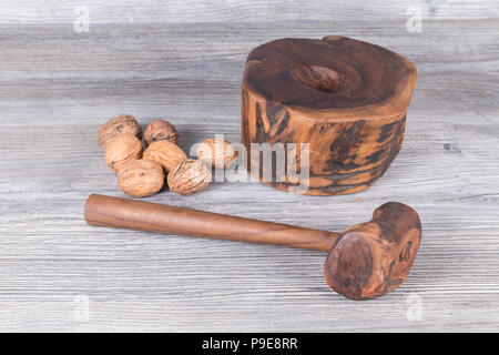 hammer nutcracker and walnuts on anthracite gray wood in background Stock Photo