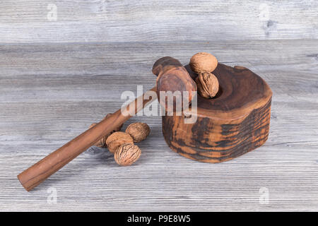 hammer nutcracker and walnuts on anthracite gray wood in background Stock Photo