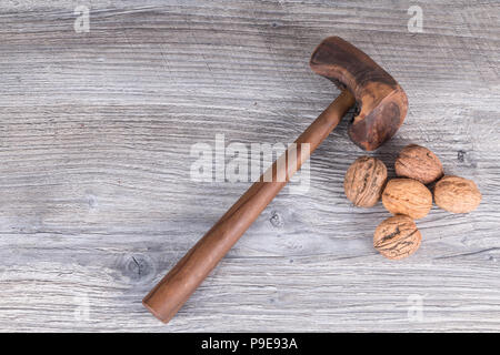 hammer nutcracker and walnuts on anthracite gray wood in background Stock Photo