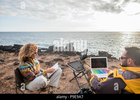 nice couple enjoying a sunset at the end of the day. travel lifestyle in wanderlust for happy cacucasian people. working alternative office with lapto Stock Photo