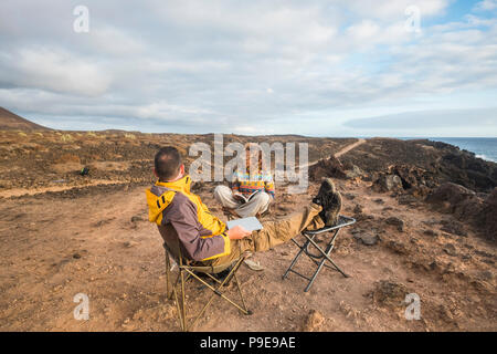 nice couple enjoying a sunset at the end of the day. travel lifestyle in wanderlust for happy cacucasian people. working alternative office with lapto Stock Photo