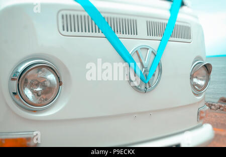 Volkswagen VW Badge on a camper van dressed in a blue wedding ribbon. Stock Photo