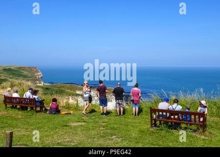 People sitting on benches overlooking the sea, Summer weather at Flamborough Head, Easy Yorkshire Stock Photo