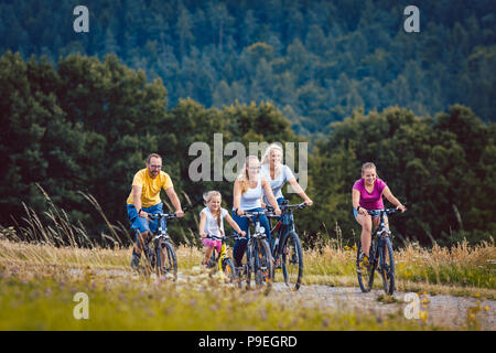 Family riding their bicycles on afternoon in the countryside Stock Photo