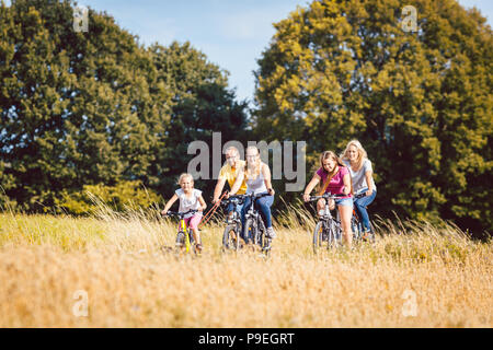 Family riding their bikes shot above a grain field Stock Photo