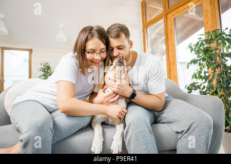 Couple with dog on the couch at home Stock Photo