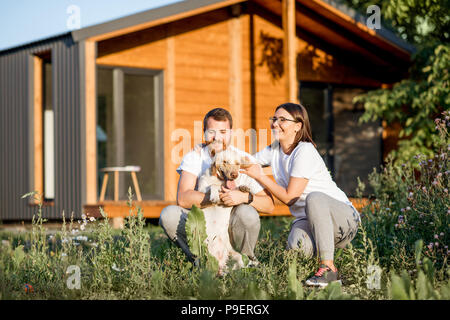 Couple with dog on the backyard of the house Stock Photo