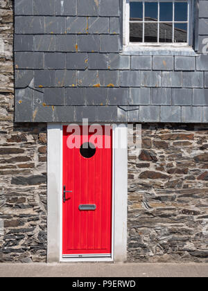 A bright red door on a granite and slate house in Padstow Cornwall UK Stock Photo