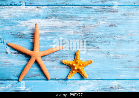 two different starfishes on a blue rustic wooden table with some blank space Stock Photo
