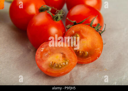 Tomatoes on baking paper, cut in half. Stock Photo