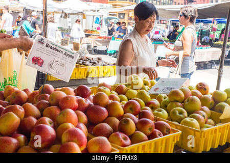 NEW YORK CITY - JULY 16, 2018: Shoppers buying produce on display at the Union Square Greenmarket farmers market in Manhattan. Stock Photo