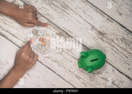 Young girls hands counting money from her piggy bank. Stock Photo