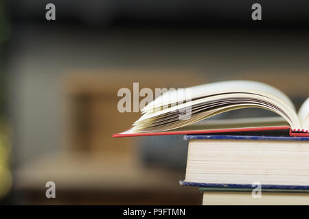 Close-up open vintage book on stack books background. Back to school concept with copy space. Books background for display your work. Stock Photo