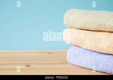 Colorful bath towels on wooden table Stock Photo