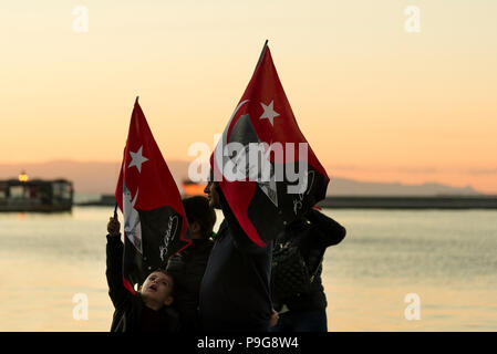 Izmir, Turkey - October 29, 2017: Family with Turkish flags with Ataturk portrait on it at Republic day of Turkey. Stock Photo