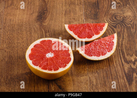 pieces of sliced fresh juicy ripe grapefruit on wooden backround Stock Photo