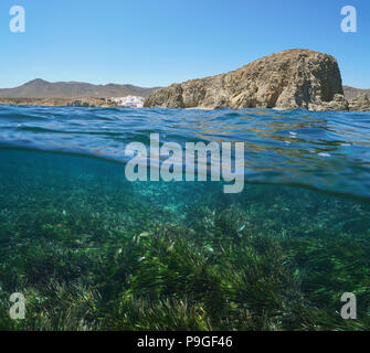 Rocky coast La Isleta del Moro with seagrass and fish underwater, split view above and below water surface, Mediterranean sea, Cabo de Gata, Spain Stock Photo