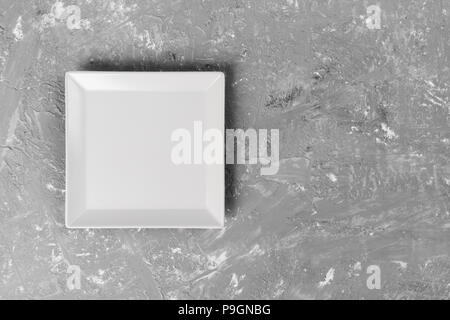 empty square plate on textured dark background. Stock Photo