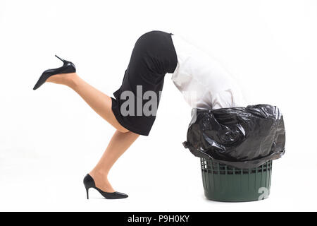 Woman stuck in trash bin with her head. Stock Photo