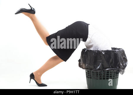 Woman stuck in trash bin with her head. Stock Photo