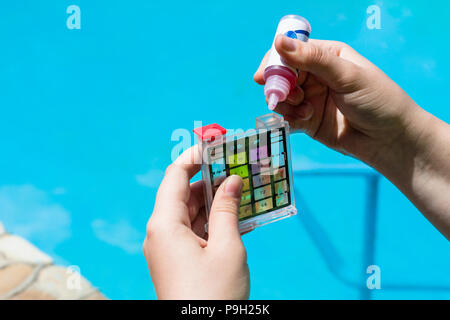 Addition of a chemical to pH meter for measure the acidity of water in a swimming pool Stock Photo