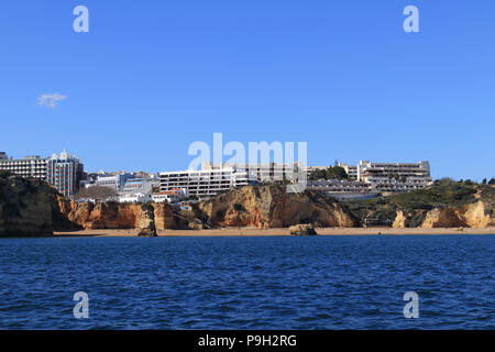 Praia Dona Ana Beach, Lagos Algarve Portugal seen from the sea. Dark blue sea and bright blue sky. Apartments and hotels on the clifftop Stock Photo