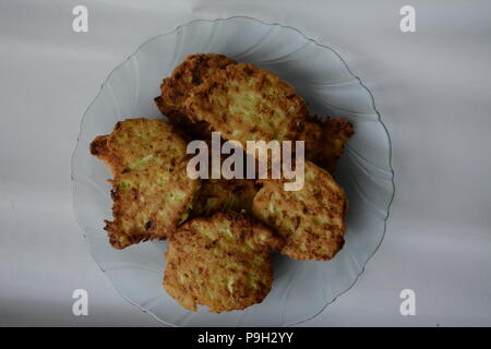 fried zucchini fritters on a wooden tablechopsticks from the fragrant green courgettes of the homemade cuisine Stock Photo