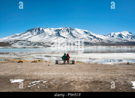 Couple watching the amazing panorama of Laguna Cañapa (Cañapa salt lake) in the Potosí Department, Bolivia. Stock Photo