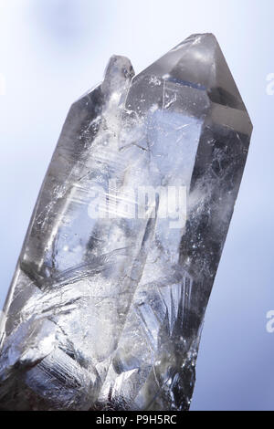 Sparkling Lemurian Quartz healing crystal used for spiritual practices and meditation on light blue background Stock Photo