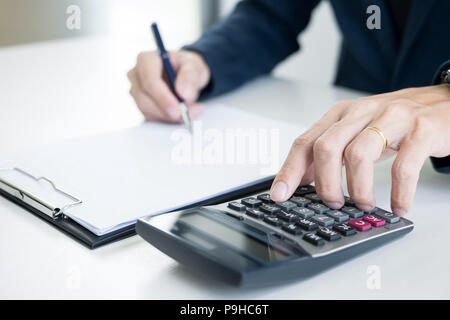 Businessman giving end key to customer after good deal agreement. while loan agreement being approved and calculator, Buy house concept Stock Photo