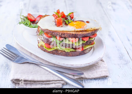 Toast from a grain bread with cheese and tomatoes and egg. Vegetarian food. on a white plate and blue dumbbells for fitness. Useful breakfast. Free space for writing text Stock Photo