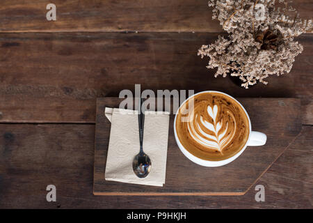 Cup of hot latte art coffee on wooden table Stock Photo