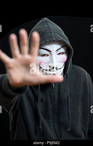 Anonymous hacker wearing a Guy Fawkes mask and a black hoodie Stock Photo