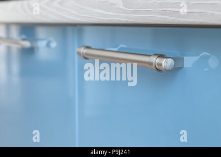 Iron handle on kitchen furniture from varnished materials. Stock Photo