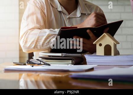 Architect working in a office. Architect writing somthing on notebook about house project in office, architectural concept Stock Photo