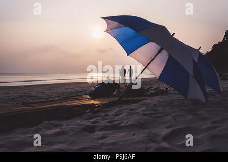 South Beach Miami Beach Umbrellas and Lounge Chairs. Two umbrellas of white and blue color lying on a deserted deserted beach on the background of a b Stock Photo