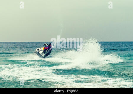 Young guy cruising on the atlantic ocean on a jet ski. Active leisure on the sea water at the aquabike competition. water entertainment at sea. summer Stock Photo