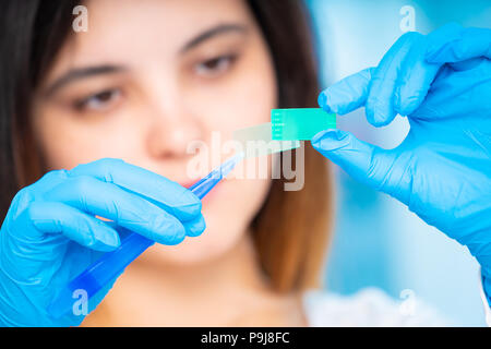 technician girl with microfluidic device LOC in microbiological lab Stock Photo
