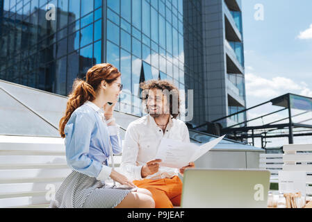 Two young creative designers working on summer terrace Stock Photo