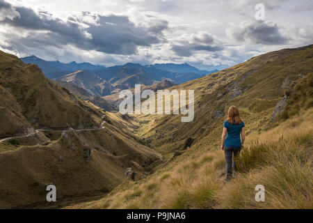 Female hiker looking down towards Skippers Canyon, Queenstown, Otago, South Island, New Zealand Stock Photo